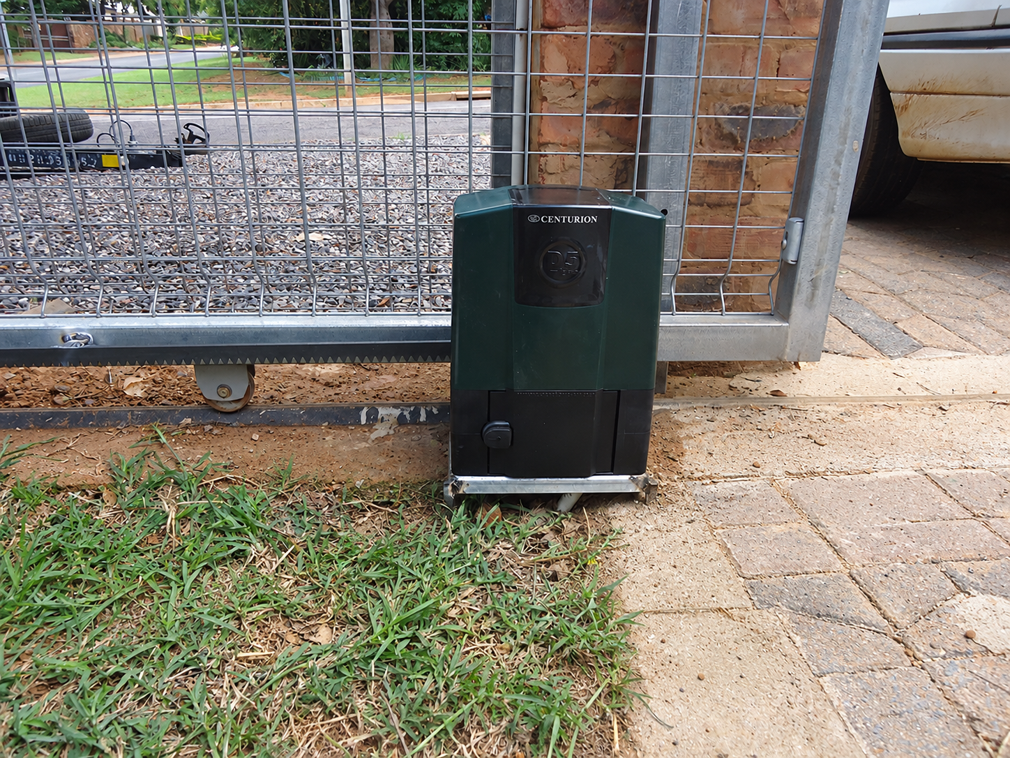 Edited Centurion D5-Evo installation photograph showing the branded motor, rack and gate track
